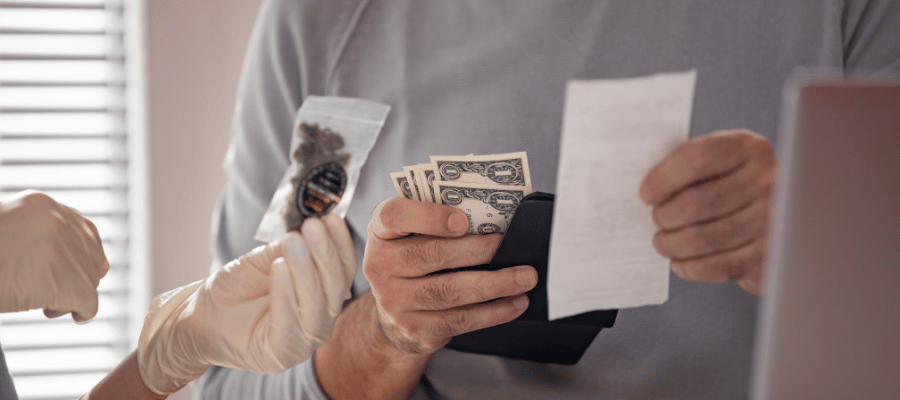 Mein Cannabis Konsum treibt mich in den Ruin: Wie du durch Eigenanbau Geld sparen kannst Mann überreicht einer Frau Geld um Cannabis zu kaufen