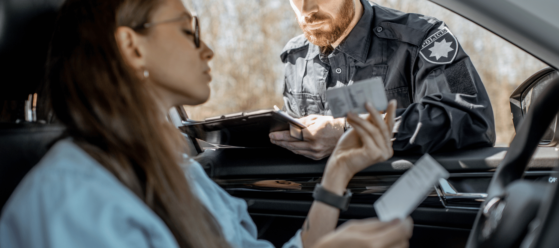 Cannabis Legalisierung 2024 und die neuen Führerscheinregeln: Was Sie wissen müssen Frau zeigt einem Polizisten im Auto, ihren Führerschein
