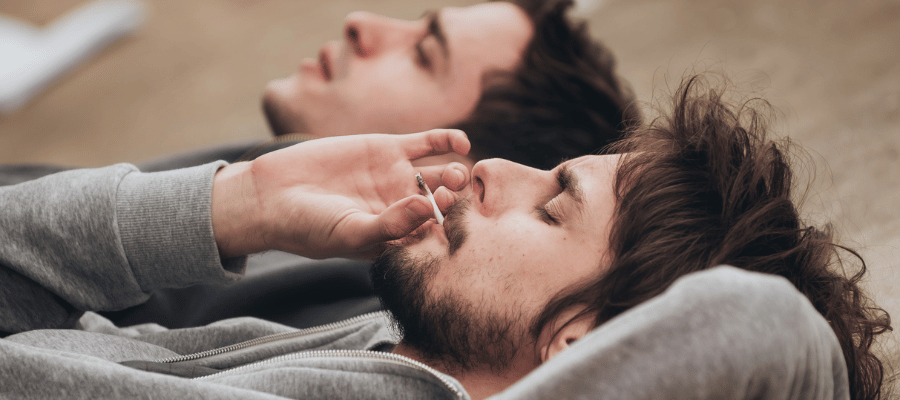 Zwei freunde die einen Cannabis Joint rauchen und liegen